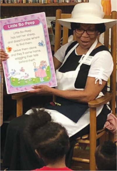 Volunteer reading a book to children