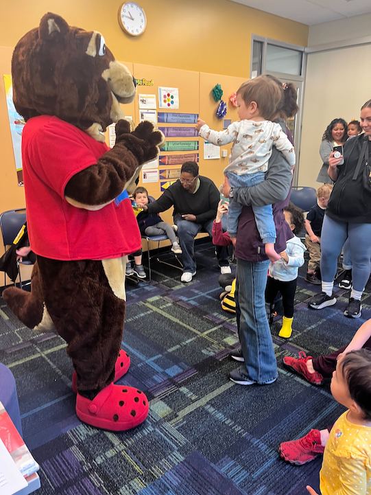 Child meets Ripple the otter mascot in Belmont's meeting room