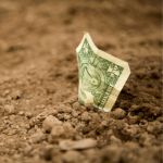 dollar bill sticking out of the ground