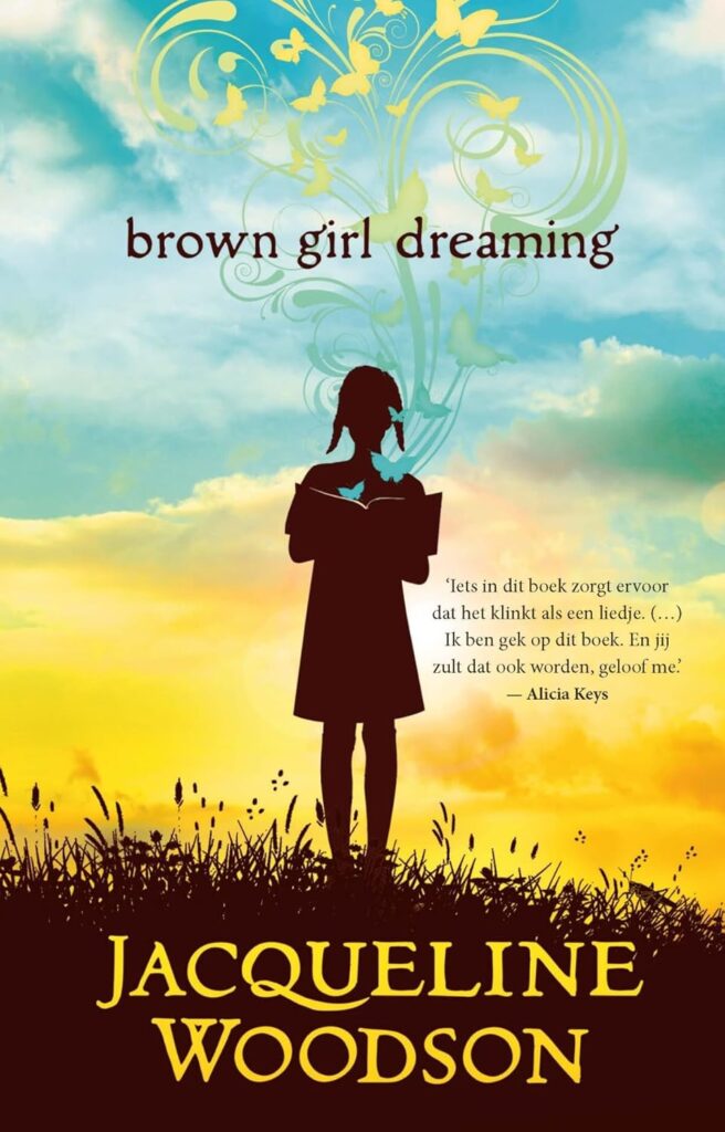 Cover of "brown girl dreaming" by Jacqueline Woodson. Silhouette of a girl reading against a vibrant sky with swirling butterflies and vines. 